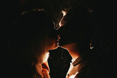 Close-up of couple kissing in the dark