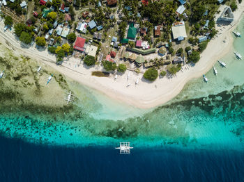 Bird's eye drone picture of a boat in the clear waters of pamilacan island, bohol, philippines
