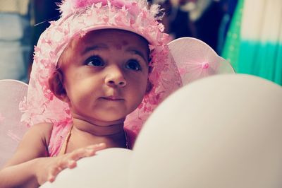 Close-up of girl wearing pink dress while looking up