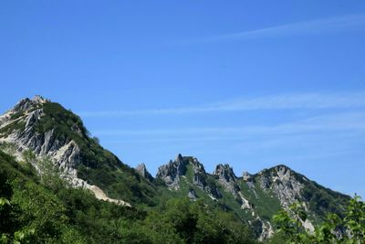 Scenic view of mountains against blue sky