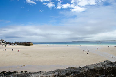 High angle view of people at beach against cloudy sky