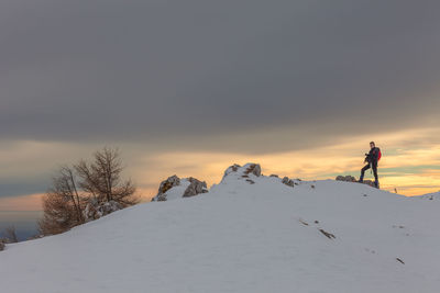 Man on snowcapped mountain against sky during winter