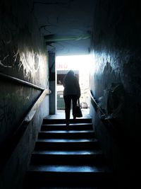 Rear view of silhouette woman walking in tunnel