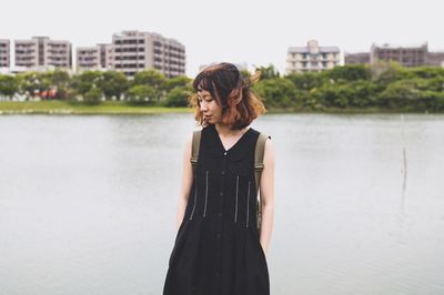 Beautiful woman standing against water