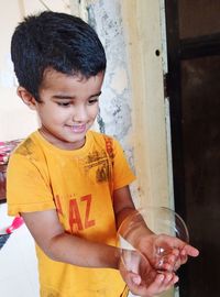 Cute boy holding bubble at home