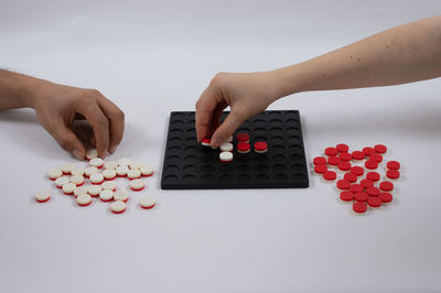 High angle view of woman hand on table against white background