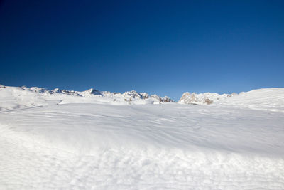 Scenic view of snowcapped mountains against clear blue sky