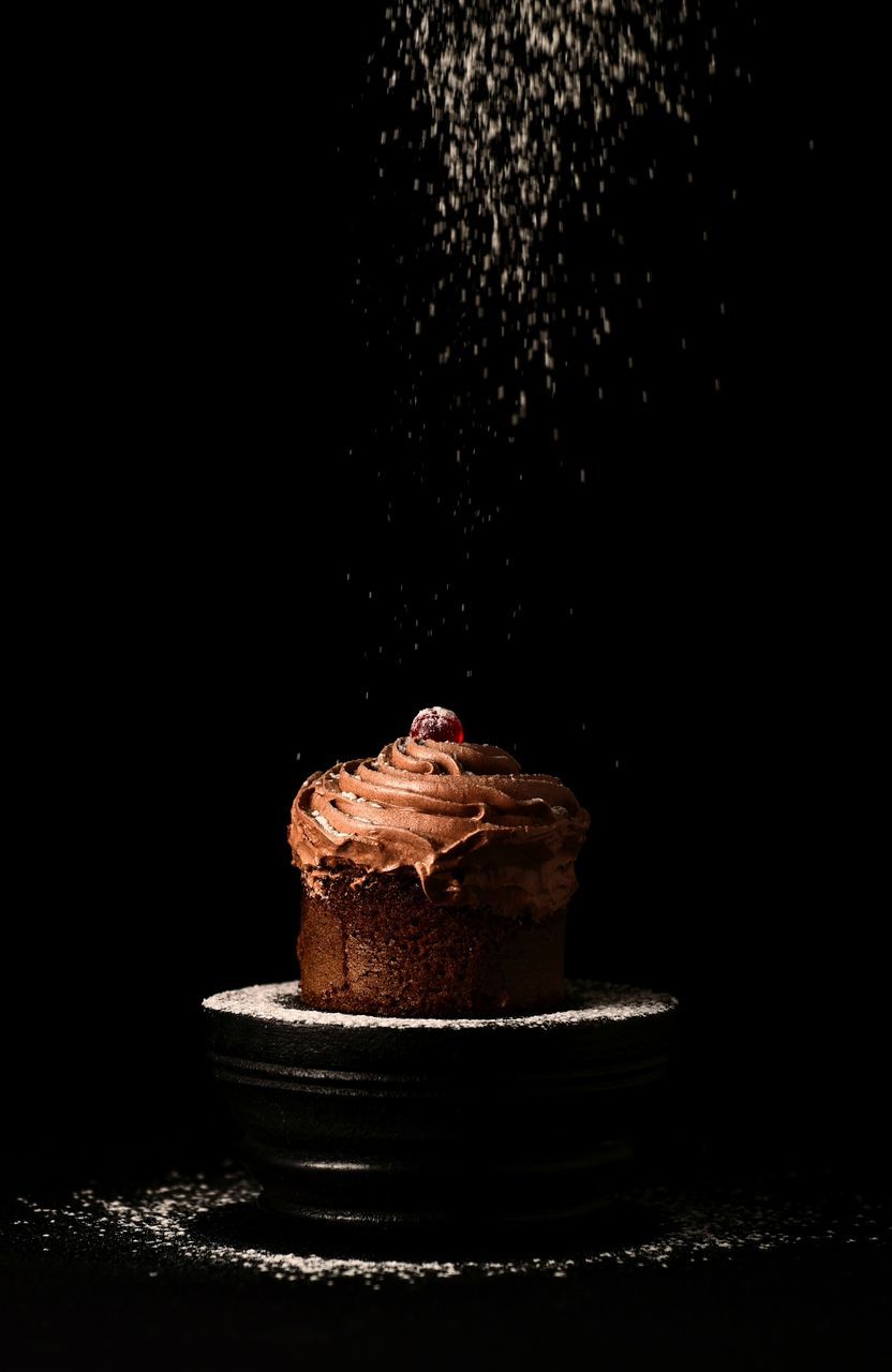 CLOSE-UP OF CHOCOLATE CAKE ON BLACK BACKGROUND