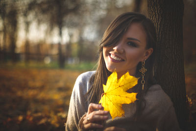 Young woman holding autumn leaves