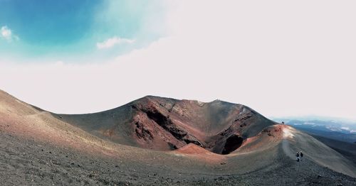Scenic view of desert against cloudy sky