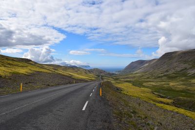 Empty road along landscape against sky