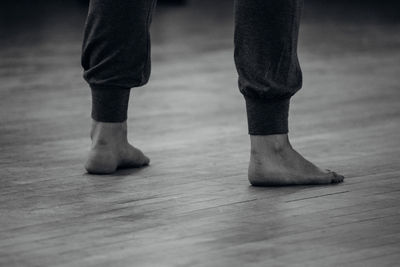 Low section of man standing on wooden floor