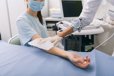 Midsection of doctor examining patient at clinic