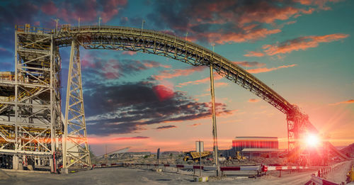 Low angle view of ferris wheel against sky during sunset