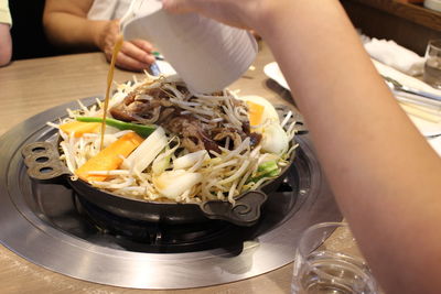 Midsection of person holding food on table