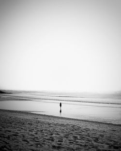 Silhouette person looking at sea against clear sky