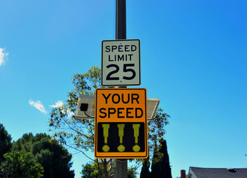 Low angle view of road sign against blue sky