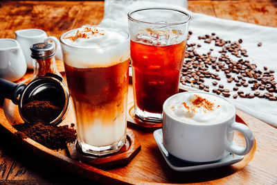 Coffee latte, cappuccino,black espresso and glass collection with coffee beans on wood table .
