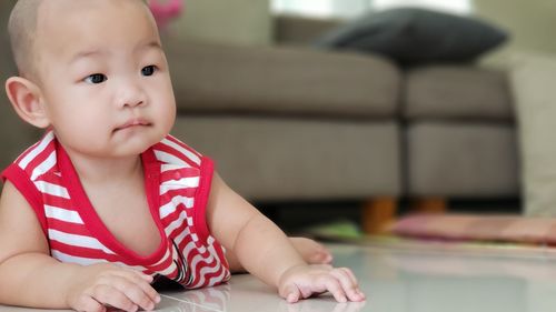 Cute boy looking away while sitting at home