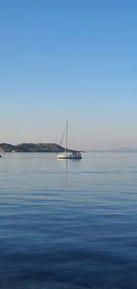 Sailboat in sea against clear sky