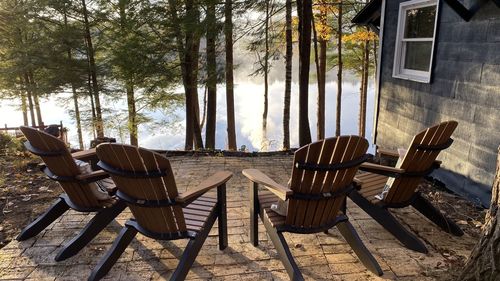 Empty chairs and table against trees