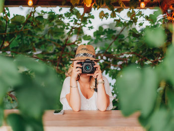 Portrait of woman holding umbrella on table