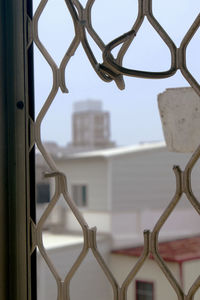 Close-up of cityscape against sky seen through window