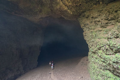 People on rock in cave