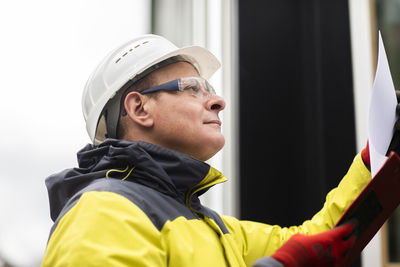 Male professional examining paper on clipboard