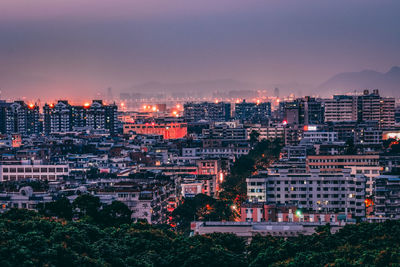 Illuminated cityscape against sky at night