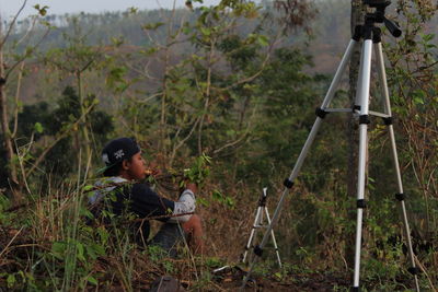 Rear view of boy sitting in forest