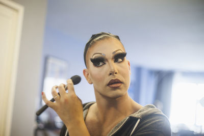 Young man applying drag makeup