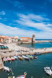 Boats moored on sea against buildings in city