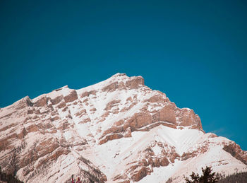 Low angle view of mountains against clear blue sky