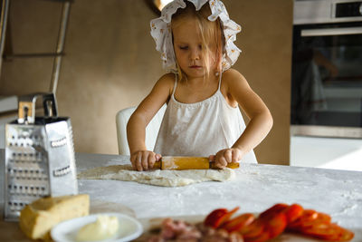 Full length of girl preparing food in kitchen