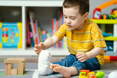 Boy playing with toy blocks at home