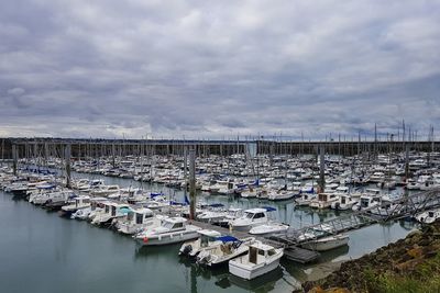 Boats moored at harbor against sky