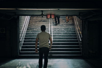 Rear view of man walking on staircase