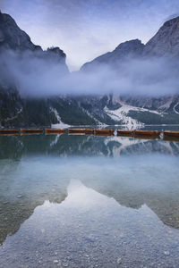 Scenic view of lake by snowcapped mountains against sky