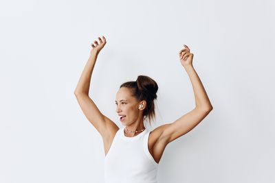 Woman with arms raised against white background