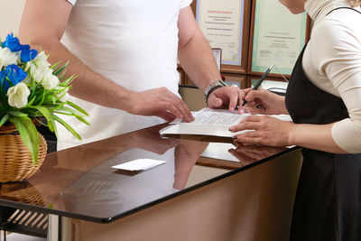 Midsection of couple holding hands at home