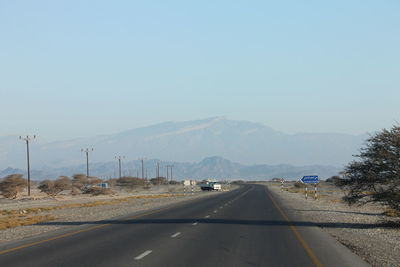 Road by mountains against clear blue sky