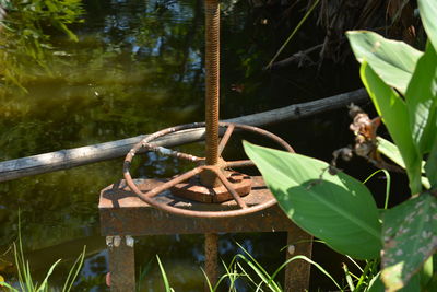 Close-up of rusty metal wheel on field