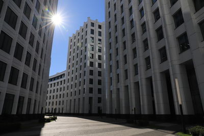 Low angle view of modern buildings against sky on sunny day