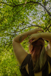 Rear view of woman standing against trees