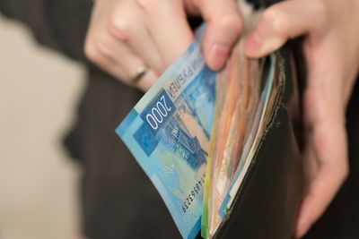 Midsection of woman removing paper currencies from wallet