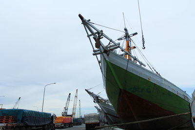 Low angle view of sailboats moored at harbor against sky