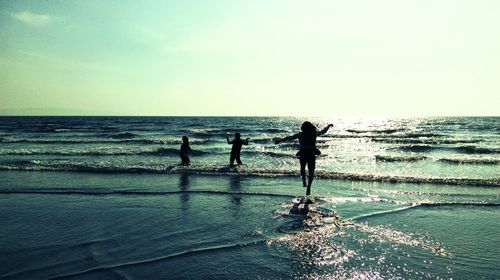 Silhouette people on calm beach