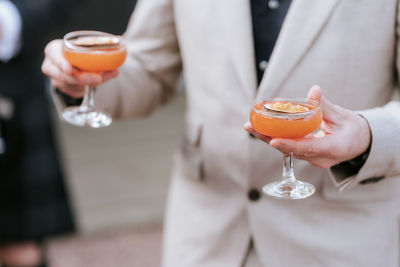 Midsection of businessman holding cocktail