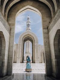 Rear view of woman walking in temple outside building